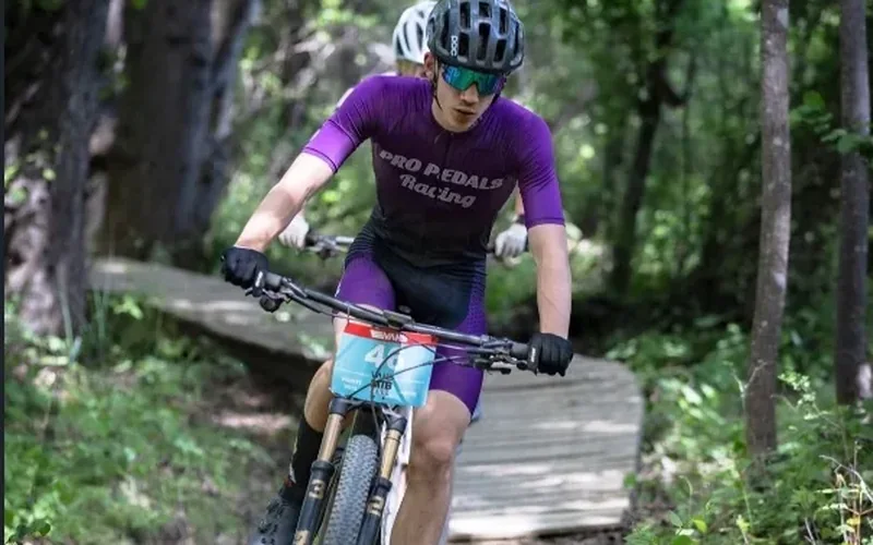 Ryan C. racing a mountain bike on a forest trail